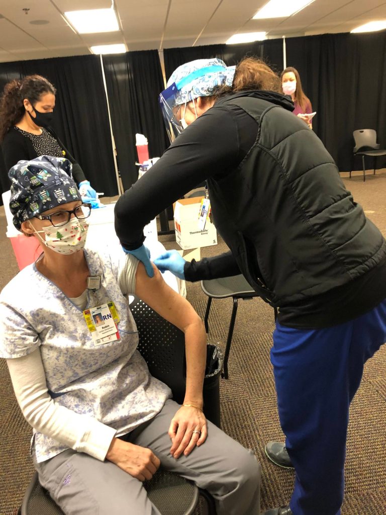 RN Heidi Marion (right) administers a dose of Pfizers COVID-19 vaccine to RN Robin Richardson (left) on Friday, Dec. 18, 2020 in Soldotna, Alaska. (Photo courtesy Bruce Richards/CPH)