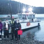 Curtis Jackson, second from right, poses on Thursday, Dec. 17, 2020, with SVT Heath & Wellness Center health care workers in Jakolof Bay, Alaska, after making a trip across Kachemak Bay from Homer to deliver the medical team and Pfizer COVID-19 vaccine. From left to right are nurse Candice Kreger, family nurse practitioner Kourtney Holder, Jackson, and family nurse practitioner Julie Drude. The health care workers then went by road to Seldovia. (Photo by Janel Harris courtesy of Mako's Water Taxi)