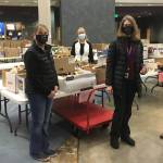 Photos by Michael S. Lockett / Juneau Empire
Members of the Juneau Education Support Staff union pose for a photo in front of meals being prepared for kids in Juneau as Catherine Pusich, second from right, hands a check from the union to Adrianne Schwartz to clear all money owed for school meals at Thunder Mountain High School on Dec. 21.