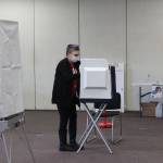 A poll worker is seen disinfecting a voting booth at the Soldotna Regional Sports Complex on Tuesday, Nov. 3 in Soldotna, Alaska. (Photo by Ashlyn OHara/Peninsula Clarion)