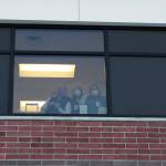 Ashlyn OHara/Peninsula Clarion
Health care workers wave from inside of Central Peninsula Hospital while awaiting the delivery of the facilitys first shipment of COVID-19 vaccines on Dec. 16 in Soldotna.