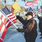 Ron Henry holds an American flag at the intersection of Kenai Spur and Sterling highways on Wednesday, Jan. 6 in Soldotna. (Ashlyn OHara/Peninsula Clarion)
