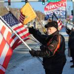 Ron Henry holds an American flag at the intersection of Kenai Spur and Sterling highways on Wednesday, Jan. 6 in Soldotna, Alaska. (Ashlyn OHara/Peninsula Clarion)