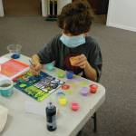 Ryder Chase, age 9, works on faux stained glass in Amy Komars socially-distant Art a la Carte class on Friday, Nov. 20, 2020, at the Homer Council on the Arts. Children in the class wore masks and worked at either end of long tables spaced apart. The stars will be placed in store windows for a dose of color therapy for the community, Komar said. (Photo by Michael Armstrong/Homer News)