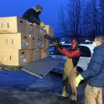 Todd Duwe hands a food box to Brad Nyquist as Mark Larson looks on Tuesday, Dec. 22, 2020, at Christ Lutheran Church in Soldotna, Alaska. The church volunteers were distributing food from the United States Department of Agricultures Farmers to Families Food Box Program, delivered by the Kenai Peninsula Food Bank. (Photo by Jeff Helminiak/Peninsula Clarion)