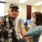 Retired school nurse Tracy Silta adminsters the COVID-19 vaccine to Drew Sparlin at the Soldotna Prep School in Soldotna, Alaska on Jan. 23, 2021. (Photo by Brian Mazurek/Peninsula Clarion)