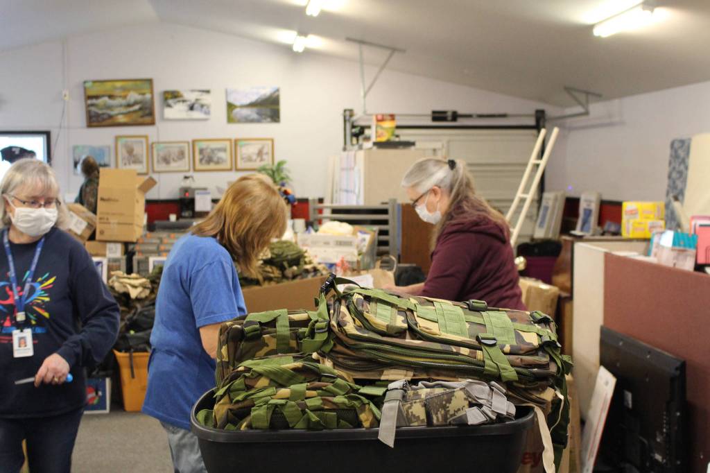 Volunteers Kathy Gensel, Mary Bell and Sherry Martinovich fill backpacks with supplies for the upcoming Project Homeless Connect event at Love, INC in Soldotna, Alaska on Jan. 22, 2021. (Photo by Brian Mazurek/Peninsula Clarion)