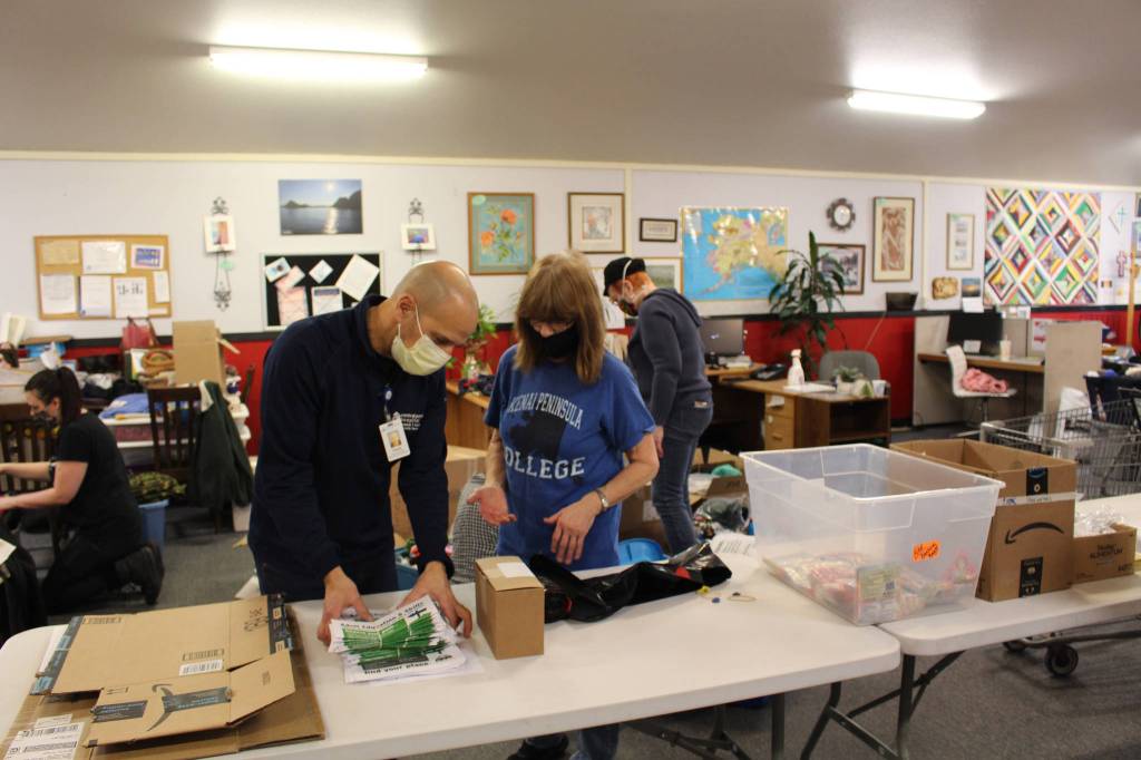Volunteers Frank Alioto and Mary Bell fill backpacks with supplies for the upcoming Project Homeless Connect event at Love, INC on Jan. 22, 2021. (Photo by Brian Mazurek/Peninsula Clarion)