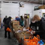 Volunteers prepare bags of shelf stable food to distribute during the upcoming Project Homeless Connect event at the Kenai Peninsula Food Bank in Soldotna, Alaska on Jan. 23, 2021. Pictured, from left: Billy Kelley, Peggy Rogers, Troy Castimore, Pat Young, Heather Schaefer, Alecia Gottlob, Bobbi Stelljes and Frank Alioto. (Photo by Brian Mazurek/Peninsula Clarion)