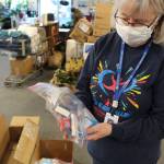 Volunteer Kathy Gensel shows some of the hygiene products included in the backpacks that will be distributed for the upcoming Project Homeless Connect event at Love, INC. in Soldotna, Alaska on Jan. 22, 2021. (Photo by Brian Mazurek/Peninsula Clarion)