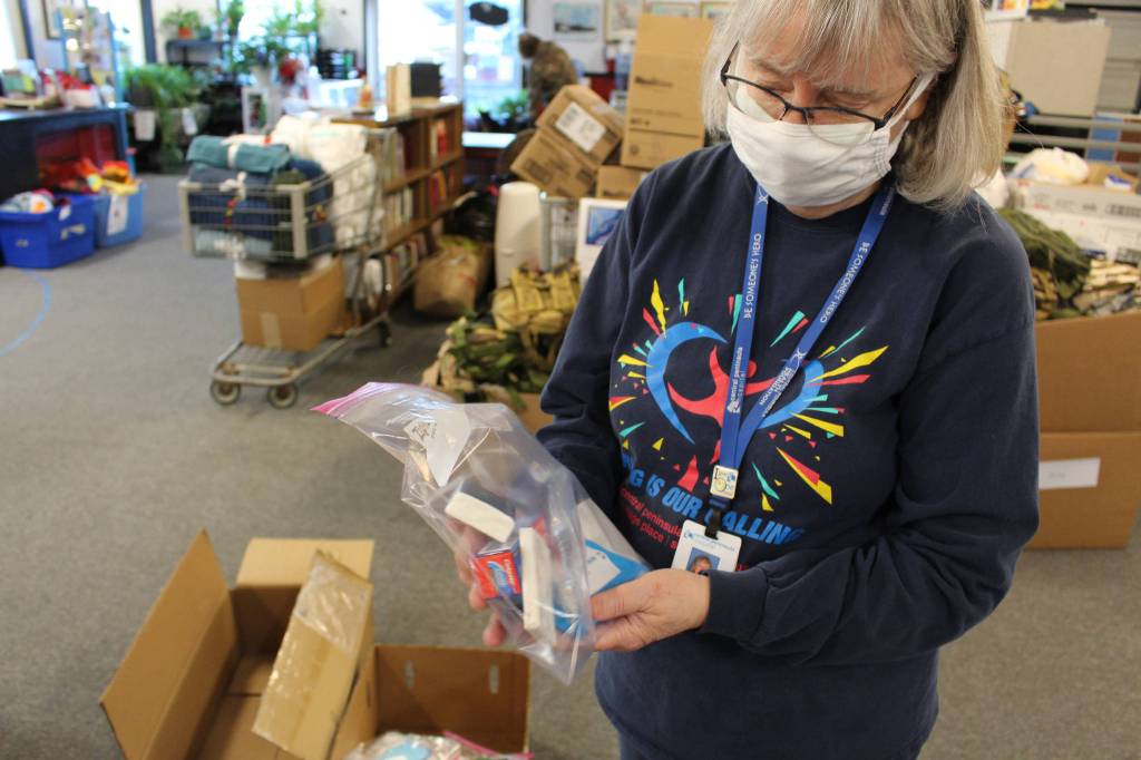 Volunteer Kathy Gensel shows some of the hygiene products included in the backpacks that will be distributed for the upcoming Project Homeless Connect event at Love, INC. in Soldotna, Alaska on Jan. 22, 2021. (Photo by Brian Mazurek/Peninsula Clarion)
