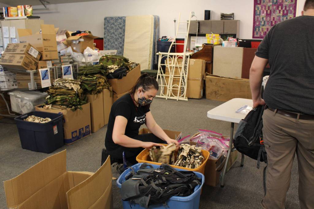 Volunter Emily Alvey looks through the backpacks that will be filled with supplies for the upcoming Project Homeless Connect Event at Love, INC. in Soldotna, Alaska on Jan. 22, 2021. (Photo by Brian Mazurek/Peninsula Clarion)