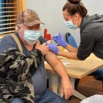 EMT Angie Parrish-Smith (right) administers a COVID-19 vaccine to John Turnbull (left) on Saturday, January 23 in Nikiski, Alaska. (Photo courtesy of the Nikiski Senior Center)