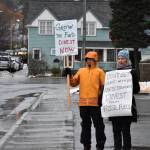 Dick Farnell, right, and Suzanne Cohen of environmental group 350Juneau hold signs outside the Alaska Permanent Fund Corporation building during APFCs Board of Directors quarterly meeting on Wednesday, Feb. 19, 2020. (Peter Segall / Juneau Empire File)