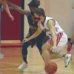 Kenai Centrals Maison Dunham drives on Homers Eyoab Knapp on Thursday, Jan. 28, 2021, at Kenai Central High School in Kenai, Alaska. (Photo by Jeff Helminiak/Peninsula Clarion)