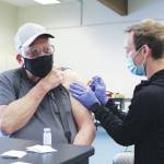 Photo by Brian Mazurek/Peninsula Clarion 
Ty Smith, paramedic/firefighter with the Nikiski Fire Department, administers the first dose of the Moderna COVID-19 vaccine to Ronald Huntsman of Nikiski during a clinic at the Nikiski Community Recreation Center on Saturday.