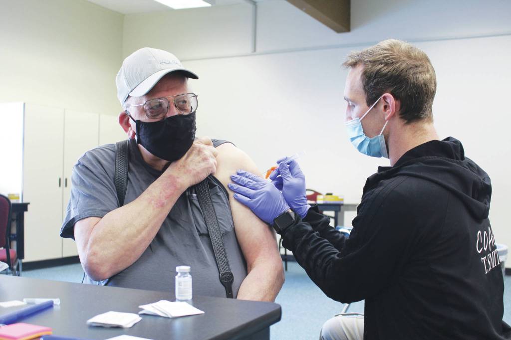 Photo by Brian Mazurek/Peninsula Clarion 
Ty Smith, paramedic/firefighter with the Nikiski Fire Department, administers the first dose of the Moderna COVID-19 vaccine to Ronald Huntsman of Nikiski during a clinic at the Nikiski Community Recreation Center on Saturday.