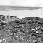 Photo from the Kenai Historical Society 
This high-angle photo shows a portion of the village of Kenai atop the bluff above the mouth of the Kenai River in about 1919, a year after the double-killing.