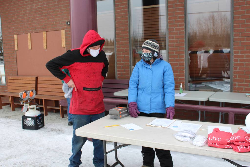 Dale Curtis, left, speaks with volunteer Heather Schaefer, right, during a Project Homeless Connect event at the Sterling Senior Citizens Center in Sterling, Alaska, on Feb. 2, 2021. (Photo by Brian Mazurek/Peninsula Clarion)