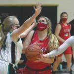 Kenai Centrals Emma Beck is fouled by Nikiskis Lillian Carstens and guarded by Avery White on Thursday, Feb. 4, 2021, at Nikiski High School in Nikiski, Alaska. (Photo by Jeff Helminiak/Peninsula Clarion)