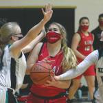 Kenai Central's Emma Beck is fouled by Nikiski's Lillian Carstens and guarded by Avery White on Thursday, Feb. 4, 2021, at Nikiski High School in Nikiski, Alaska. (Photo by Jeff Helminiak/Peninsula Clarion)