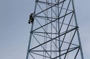Billy Adamson scales a communications tower on Thursday, Jan. 7 in Nikiski, Alaska. (Ashlyn OHara/Peninsula Clarion)