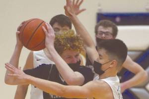Nikiski's Brady Bostic faces pressure from Soldotna's Daniel McRorie on Saturday, Feb. 13, 2021, at Soldotna High School in Soldotna, Alaska. (Photo by Jeff Helminiak/Peninsula Clarion)