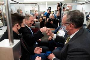 Michael van der Veen, second from left an attorney for former President Donald Trump, fist bumps a colleague as the depart on the Senate Subway, on Capitol Hill after the Senate acquitted Trump in his second impeachment trial in the Senate at the U.S. Capitol in Washington, Saturday, Feb. 13, 2021. Trump was accused of inciting the Jan. 6 attack on the U.S. Capitol, and the acquittal gives him a historic second victory in the court of impeachment. (AP Photo/Alex Brandon)