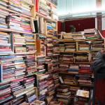Benjamin Jackinsky stands next to bookshelves inside of Already Read on Friday, Feb. 19 in Kenai, Alaska. (Ashlyn OHara/Peninsula Clarion)