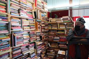 Benjamin Jackinsky stands next to bookshelves inside of Already Read on Friday, Feb. 19 in Kenai, Alaska. (Ashlyn OHara/Peninsula Clarion)