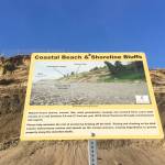 A sign describing bluff erosion is seen on Kenai North Beach in Kenai, Alaska, on Aug. 6, 2020. (Photo by Jeff Helminiak/Peninsula Clarion)
