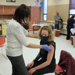Tracy Silta (left) administers a dose of a COVID-19 vaccine to Melissa Linton during a vaccine clinic at Soldotna Prep School on Friday, Feb. 26 in Soldotna, Alaska. (Ashlyn OHara/Peninsula Clarion)
