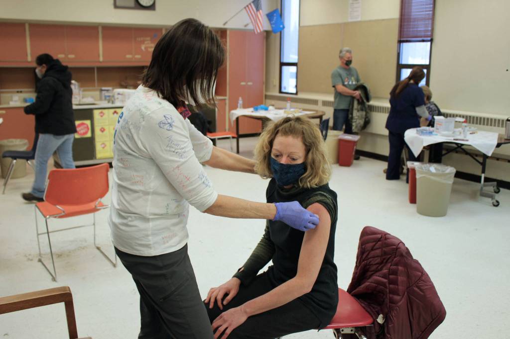 Tracy Silta (left) administers a dose of a COVID-19 vaccine to Melissa Linton during a vaccine clinic at Soldotna Prep School on Friday, Feb. 26 in Soldotna, Alaska. (Ashlyn OHara/Peninsula Clarion)