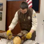 Daniel Saxton demonstrates how to use a draw knife during the Kenai Wildlife Refuges remote Speaker Series on cabins on Friday, Feb. 26 in Kenai, Alaska. (Screenshot)