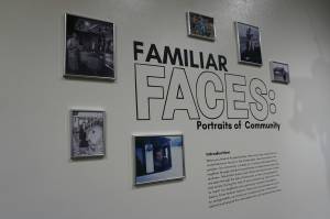 A collage of photographs surrounds the description of Familiar Faces: Portrait of a Community, on exhibit through May 2021 at the Pratt Museum in Homer, Alaska. (Photo by Michael Armstrong/Homer News)