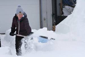 Judi Westfall shovels snow at her home in Anchorage, Alaska, on Thursday, March 11, 2021. Residents in some parts of Alaskas largest city woke Thursday to a surprise: up to 18 new inches of snow. (AP Photo/Mark Thiessen)