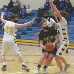 Birchwood Christians Jackson Hanson drives to the basket against Cook Inlet Academys Grizzly Beard and Mason Zeigler on Thursday, March 18, 2021, in the Peninsula Conference tournament at Soldotna High School in Soldotna, Alaska. (Photo by Jeff Helminiak/Peninsula Clarion)