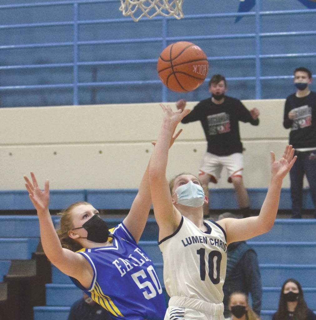 Lumen Christis Emily Ross drives to the basket on Cook Inlet Academys Hope Hillyer during the Peninsula Conference championship game Friday, March 19, 2021, at Soldotna High School in Soldotna, Alaska. (Photo by Jeff Helminiak/Peninsula Clarion)