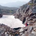 Archaeologist examining ice patch in Lake Clark National Park and Preserve. (Photo by National Park Service)