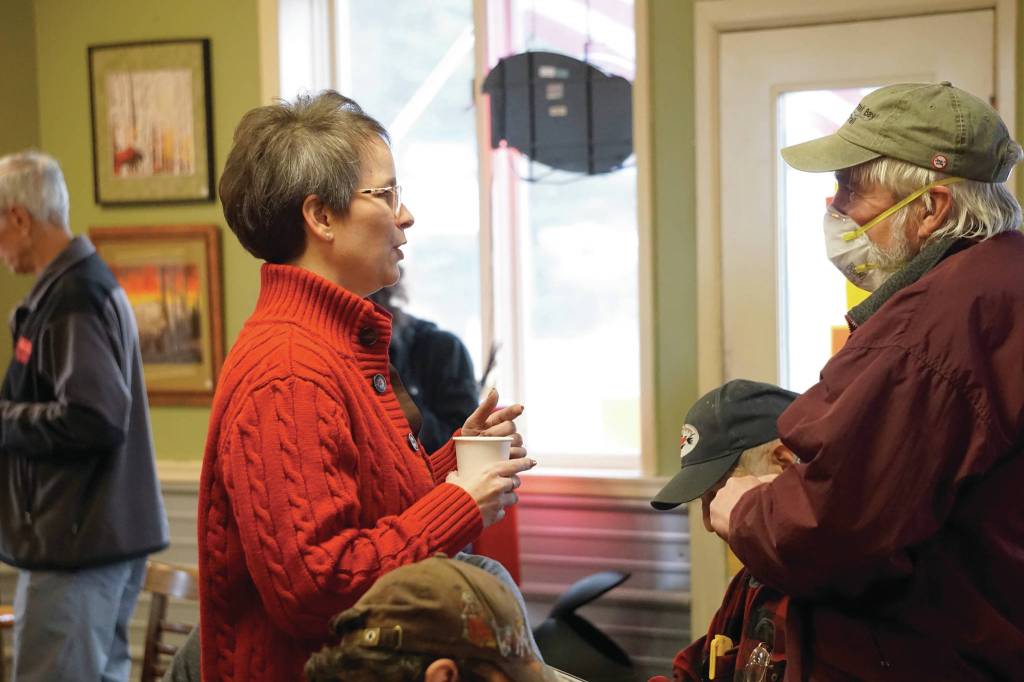 Rep. Sarah Vance, R-Homer, left, speaks with Robert Archibald, right, before holding a town hall meeting on Monday, March 29, 2021, at Captains Coffee in Homer, Alaska. Archibald was only one of four people who wore face masks at the event of about 55 people. (Photo by Michael Armstrong/Homer News)