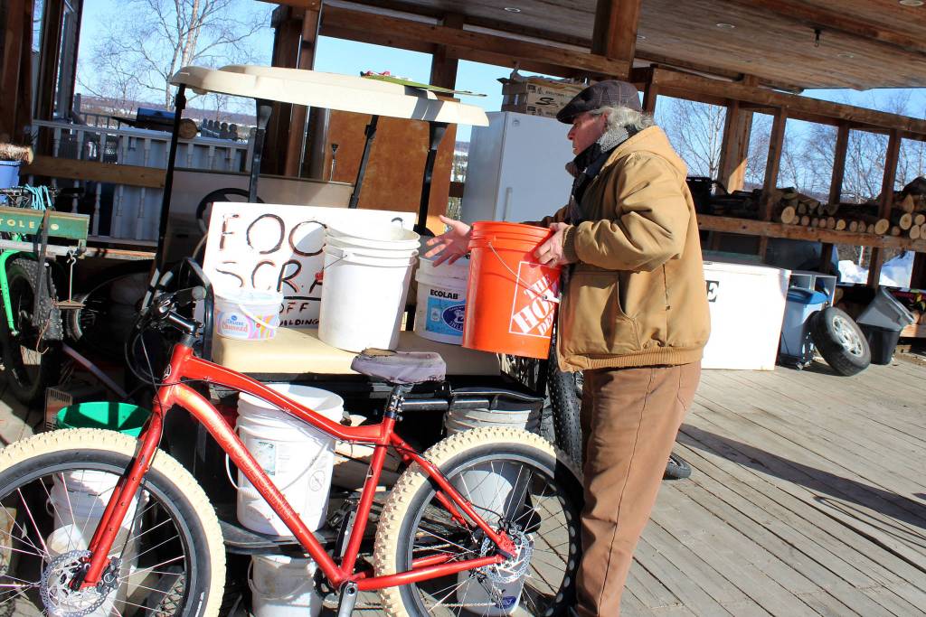 Timm Johnson collects compost buckets at Diamond M Ranch and Resort on Thursday, April 1, 2021, in Kenaie Alaska. (Ashlyn OHara/Peninsula Clarion)