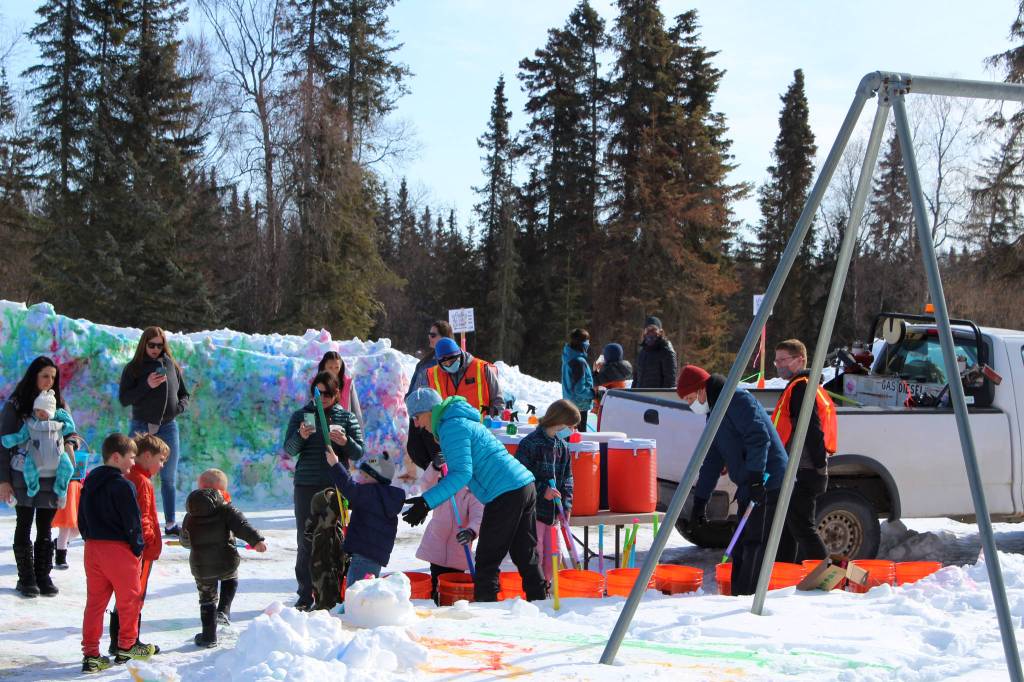 Volunteers help families load spray bottles with color at an easter event at Kenai Municipal Park on Friday, April 2, 2021 in Kenai, Alaska. (Ashlyn OHara/Peninsula Clarion)