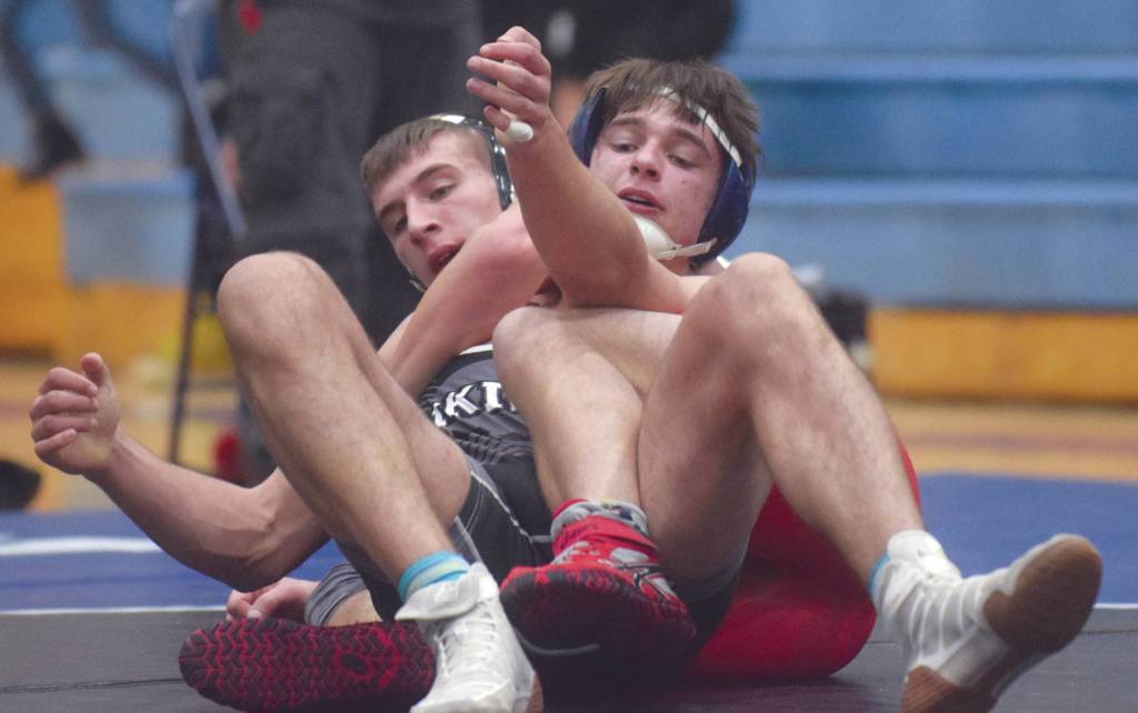 Kenai Centrals Tucker Vann and Nikiskis Caileb Payne tangle Friday, April 3, 2021, at Soldotna High School in Soldotna, Alaska. Vann won by an 11-6 decision. (Photo by Jeff Helminiak/Peninsula Clarion)
