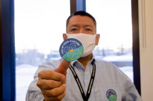In this undated photo provided by the Tanana Chiefs Conference, shows PJ Simon, chief and chairman of the conference, from Fairbanks, Alaska, displaying a COVID-19 vaccination sticker. Alaska has been one of the leading states in the percentage of its population to be vaccinated against COVID-19. But some of Alaskas highest vaccination rates have been in some of its most remote, hardest-to-access communities, where the toll of past flu or tuberculosis outbreaks hasnt been forgotten. (Rachel Saylor/Tanana Chiefs Conference via AP)