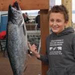Andrew Marley, the 2021 Homer Winter King Salmon Tournament winner, points to his prize winning 25.62-pound white king salmon on Saturday, April 17, 2021, on the Homer Spit in Homer, Alaska. (Photo by Michael Armstrong/Homer News)
