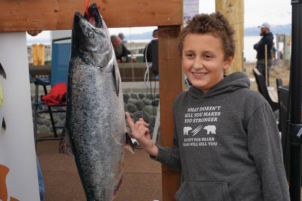 Andrew Marley, the 2021 Homer Winter King Salmon Tournament winner, points to his prize winning 25.62-pound white king salmon on Saturday, April 17, 2021, on the Homer Spit in Homer, Alaska. (Photo by Michael Armstrong/Homer News)