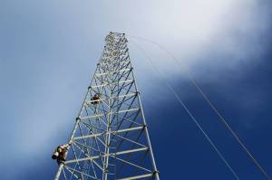 Billy Adamson (left) and Adam Kiffmeyer scale a communications tower on Thursday, Jan. 7 in Nikiski, Alaska. Homer-based SPITwSPOTS was one of the telecommunications companies awarded CARES money by the Kenai Peninsula Borough as part of an effort to increase public access to the internet. (Ashlyn OHara/Peninsula Clarion)