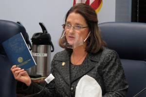 In this Jan. 27, 2021 file photo, Alaska state Sen. Lora Reinbold, an Eagle River Republican, holds a copy of the Alaska Constitution during a committee hearing in Juneau, Alaska. Alaska Airlines has banned the Alaska state senator for refusing to follow mask requirements. Last week Reinbold was recorded in Juneau International Airport arguing with Alaska Airlines staff about mask policies. A video posted to social media appears to show airline staff telling Reinbold her mask must cover her nose and mouth. Reinbold has been a vocal opponent to COVID-19 mitigation measures and has repeatedly objected to Alaska Airlines mask policy, which was enacted before the federal governments mandate this year. (AP Photo/Becky Bohrer, File)