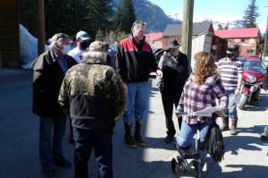 Alaska Gov. Mike Dunleavy, center, meets with people near an outdoor COVID-19 vaccination clinic in Hyder, Alaska, on Thursday, April 22, 2021. Dunleavy said Alaska is in a fortunate position with its vaccine supply and he wants to share vaccines with people across the border in Stewart, British Columbia, a community that has close ties to Hyder. (AP Photo/Becky Bohrer)