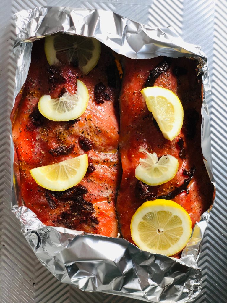 Victoria Petersen/Peninsula Clarion
Salmon dressed up with sun-dried tomatoes and lemons is ready to go in the oven.